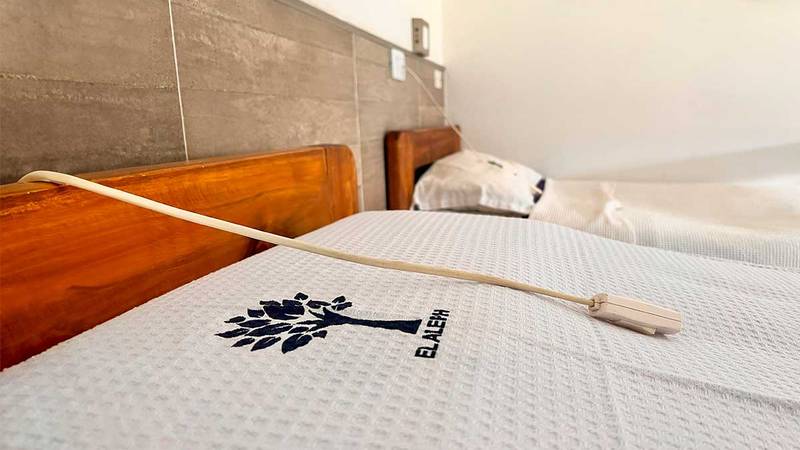 Cama de una habitación con el logo de El Aleph
